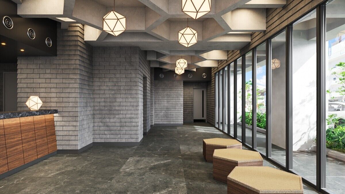 A modern lobby with a reception desk, geometric ceiling lights, and a glass wall offering a view of the outdoors.