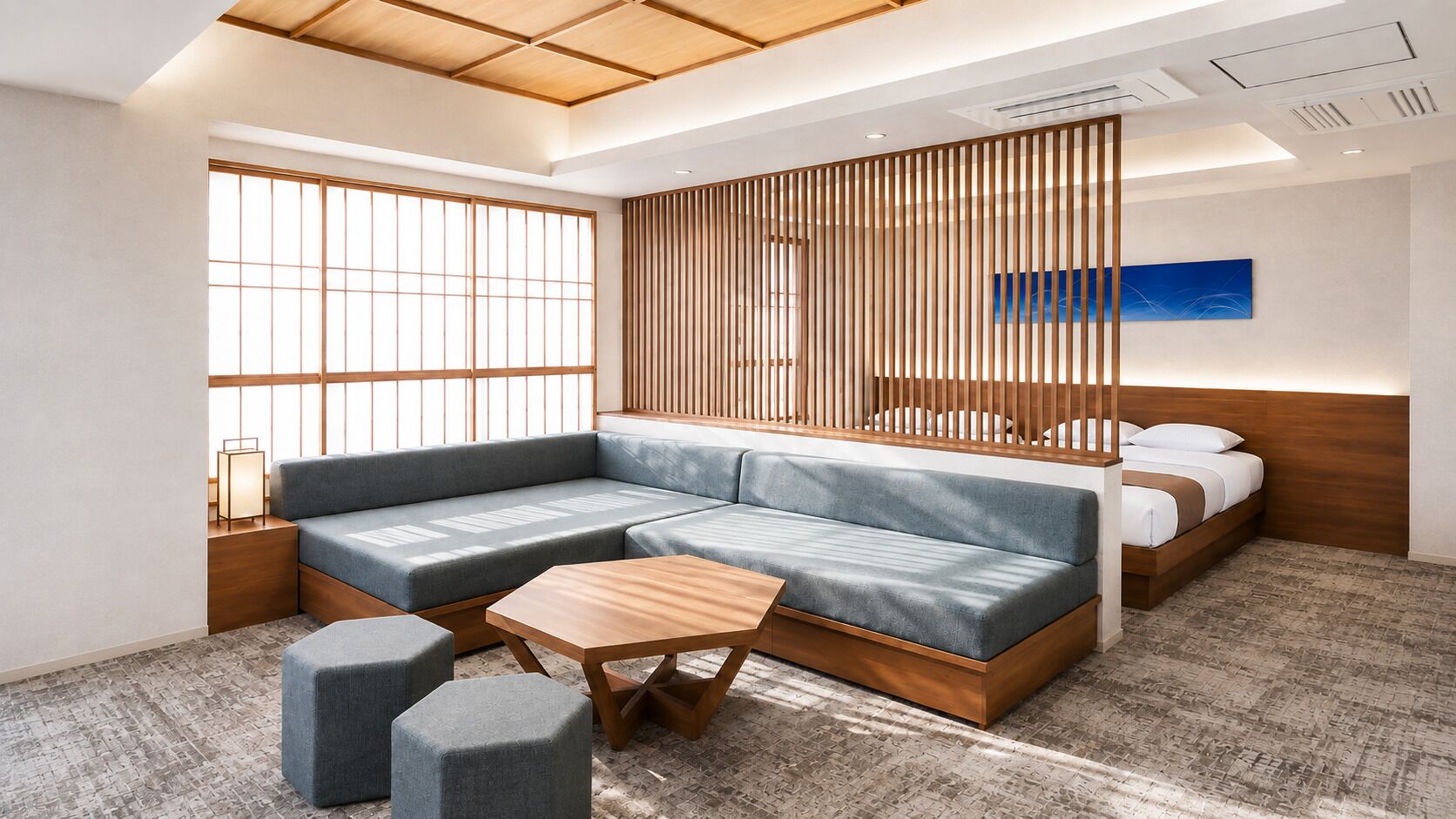 A modern hotel room with a sectional sofa, a wooden coffee table, and a bed with a wooden headboard.