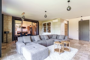 A modern living room with a sectional sofa, a small wooden table, and a white rug. - A comfortable home on the riverbank near Ussé (Rigny-Ussé)