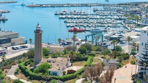 A marina with boats, a lighthouse, and a building with a dome. - Estepona Old Town (200 meters from the beach) (Estepona)