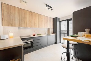 Eine moderne Küche mit Holzausstattung, integriertem Backofen, Spüle und einem Essbereich mit Hockern.