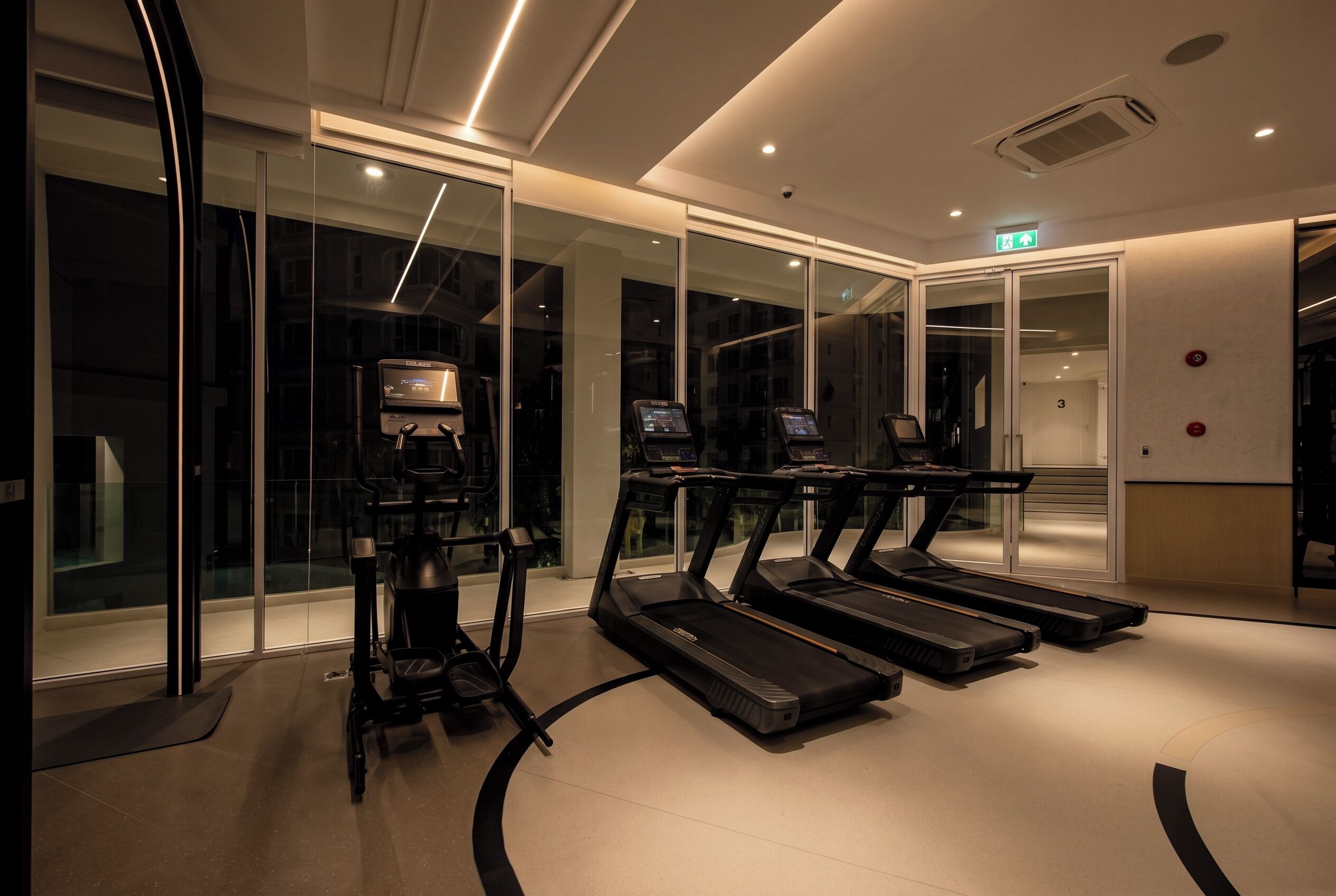 A fitness center with treadmills and a stationary bike, glass walls, and a clean, modern design.
