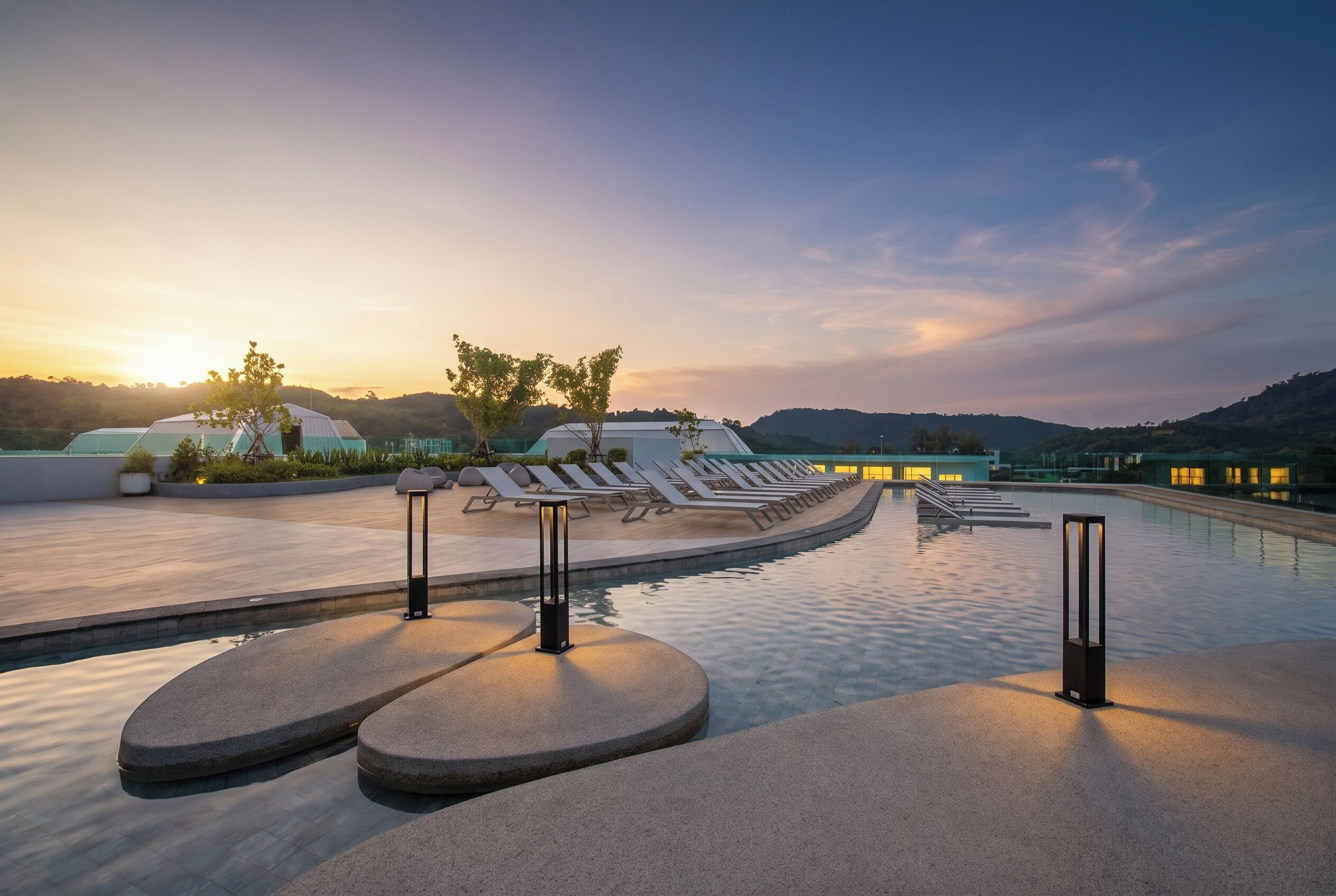 Un espace aménagé au bord de la piscine, avec des chaises longues et un ciel dégagé.