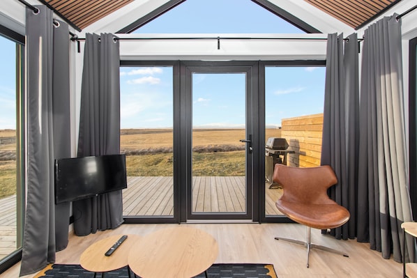 A modern room with a large sliding glass door leading to an outdoor deck.