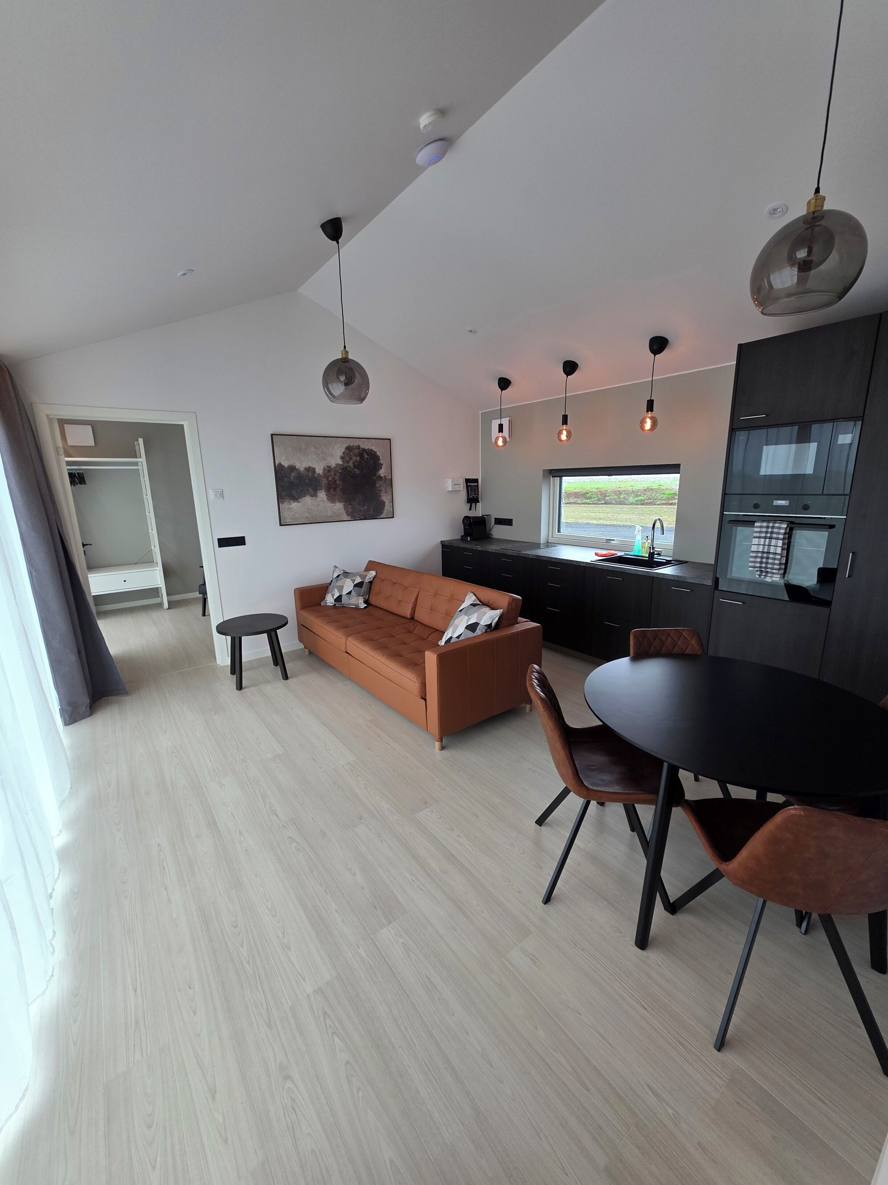 Ein stilvoller Wohnbereich mit Sofa, Esstisch und Küchenzeile.