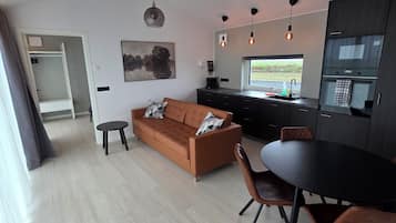 Ein stilvoller Wohnbereich mit Sofa, Esstisch und Küchenzeile.