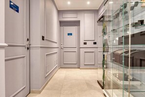 A hallway with double doors, a glass display case, and a sign indicating a room number. - VivimiHome-Suite Topazio, Luxury Apartment (Milan)