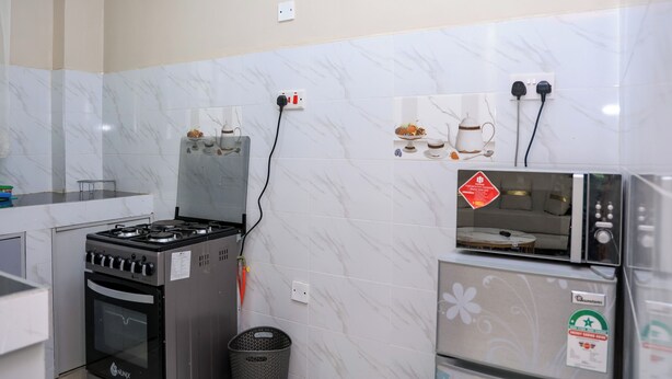 Una cucina attrezzata con piano cottura a gas, forno, microonde e frigorifero.