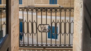 A balcony with a wrought iron railing and a view of buildings with blue shutters. - 3BR Townhouse with Private Pool & BBQ in Birkirkara (Birkirkara)