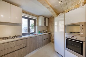 Una cocina moderna con estufa a gas, horno y armarios empotrados.