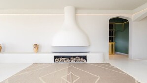 A modern interior with a white fireplace, a patterned rug, and a minimalist design. - Fresnaye Villa, Moroccan Escape & Two Pools (Cape Town)