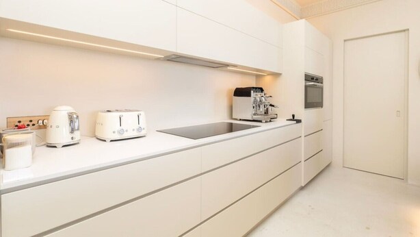 A modern kitchen with white cabinetry, a built-in oven, a coffee machine, and a toaster. - Fresnaye Villa, Moroccan Escape & Two Pools (Cape Town)