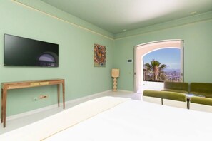 A room with a television, a painting, a lamp, a sofa, and a view through a door. - Fresnaye Villa, Moroccan Escape & Two Pools (Cape Town)