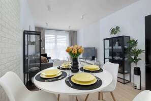 Ein modernes Wohnzimmer mit Essbereich für vier Personen.