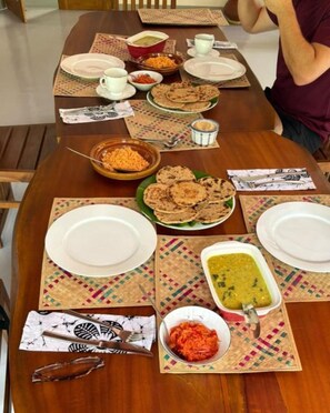 Mesa lista para comer, con platos, tazones y cubiertos.