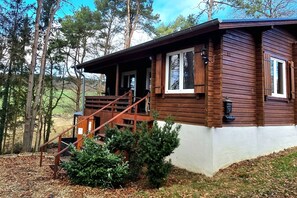 Eine Holzhütte mit Veranda, Treppe und einem kleinen Garten.