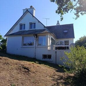 Ein zweistöckiges Haus mit Satteldach, Schornstein und Satellitenschüssel.