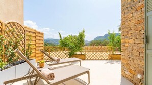 A balcony with two sun loungers, a wooden fence, and a stone wall. - MAISON BAOU ET CHOCOLAT (La Cadiere-d'Azur)