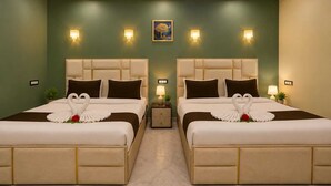 Habitación de hotel con dos camas, cada una con una toalla con forma de cisne y una mesita con lámpara.