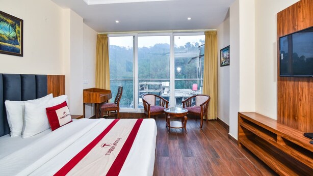 A hotel room with a large bed, a desk, a chair, and a TV. - The Jade Mountain by O9 Stay (Banikhet)