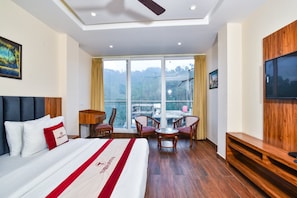 Una habitación de hotel con una cama grande, un escritorio, una silla y un televisor.