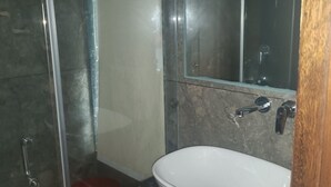 A bathroom with a glass shower enclosure, a white sink, and a mirror above it. - The Jade Mountain by O9 Stay (Banikhet)
