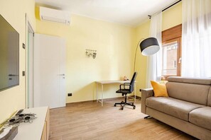 A living room with a sofa, a desk, and a chair. - App.to Del Paradosso: cozy, in the town center, quiet, and pet-friendly (Spilamberto)