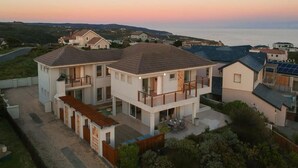 A two-story residential building with a balcony, a swimming pool, and a view of the sea. - Pezula Fairlead Luxury 7A  (Knysna)