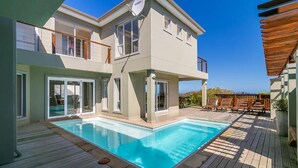 A two-story house with a swimming pool, wooden deck, and outdoor seating area. - Pezula Fairlead Luxury 7A  (Knysna)