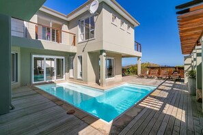 A two-story house with a swimming pool, wooden deck, and outdoor seating area. - Pezula Fairlead Luxury 7A  (Knysna)
