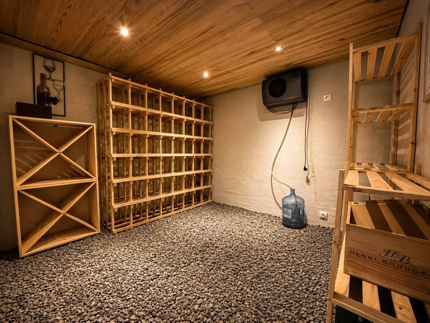 A room with a wooden ceiling, a large wooden shelving unit, a water dispenser, and a wooden rack with a label.