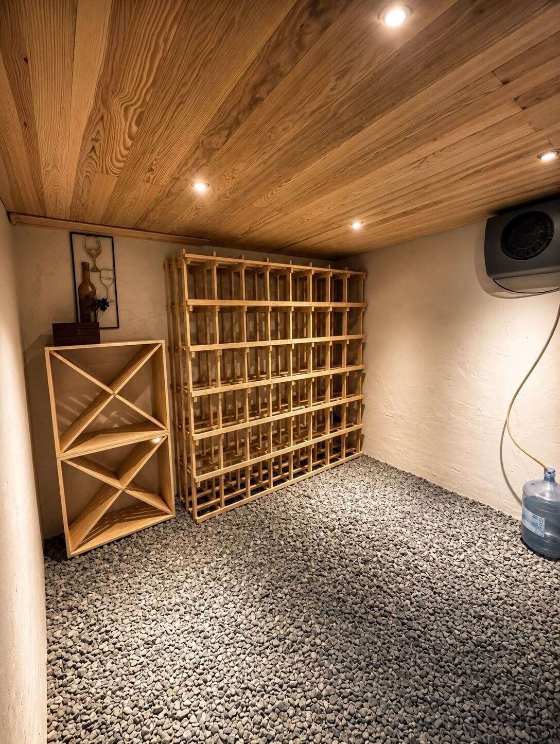 Ein Zimmer mit Holzboden, einem integrierten Weinkühlschrank und einem Wasserspender.