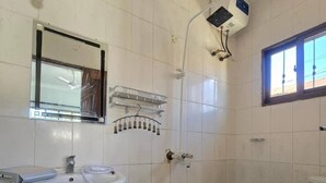 A bathroom with a sink, mirror, shower, and toilet.