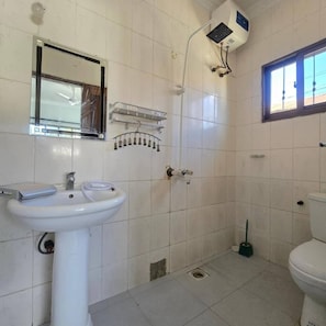 A bathroom with a sink, mirror, shower, and toilet. - FURAVIA AFRICA STAY  (Moshi)