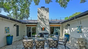 A patio with a brick wall, outdoor furniture, and a chimney.