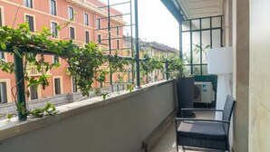 A balcony with a view of buildings, a chair, and a potted plant. - VivimiHome-Suite Casa Degli Specchi (Milan)