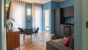 A modern living space with a dining area, kitchen, and seating area. - VivimiHome-Suite Casa Degli Specchi (Milan)