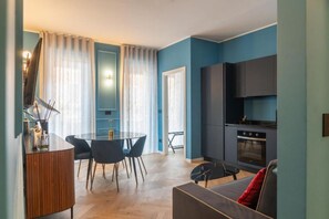 A modern living space with a dining area, kitchen, and seating area. - VivimiHome-Suite Casa Degli Specchi (Milan)