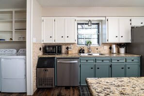 A kitchen with white cabinets, a microwave, a dishwasher, and a sink. - The Getaway - Sleeps 12 (Belton)