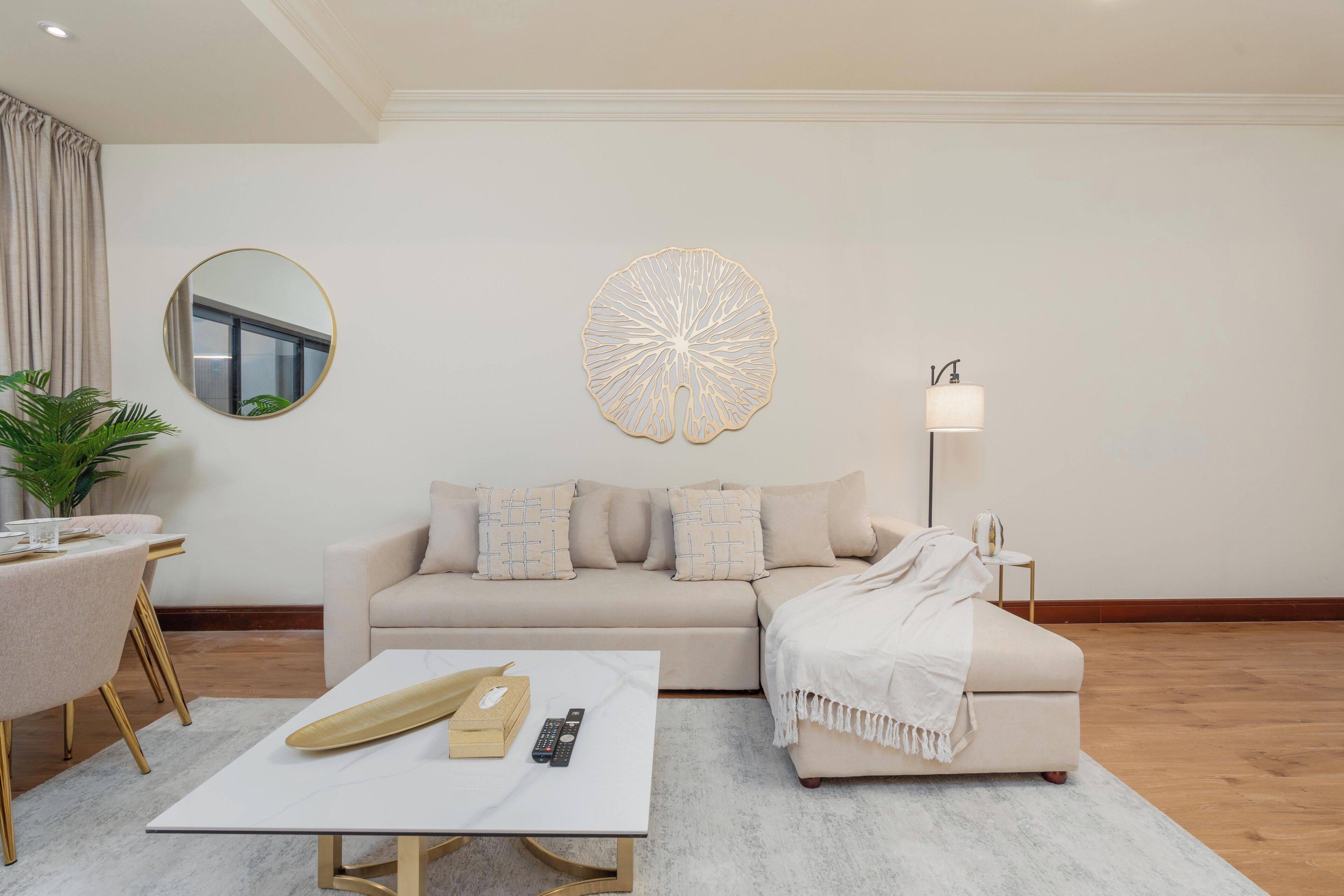 A modern living room with a sofa, coffee table, and a decorative wall piece.