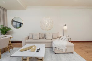 Ein modernes Wohnzimmer mit Sofa, Couchtisch und einer Wanddekoration.