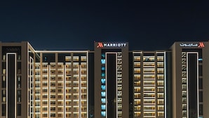 A multi-story hotel building with illuminated signage indicating it is a Marriott property.