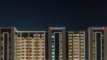 A multi-story hotel building with illuminated signage indicating it is a Marriott property.