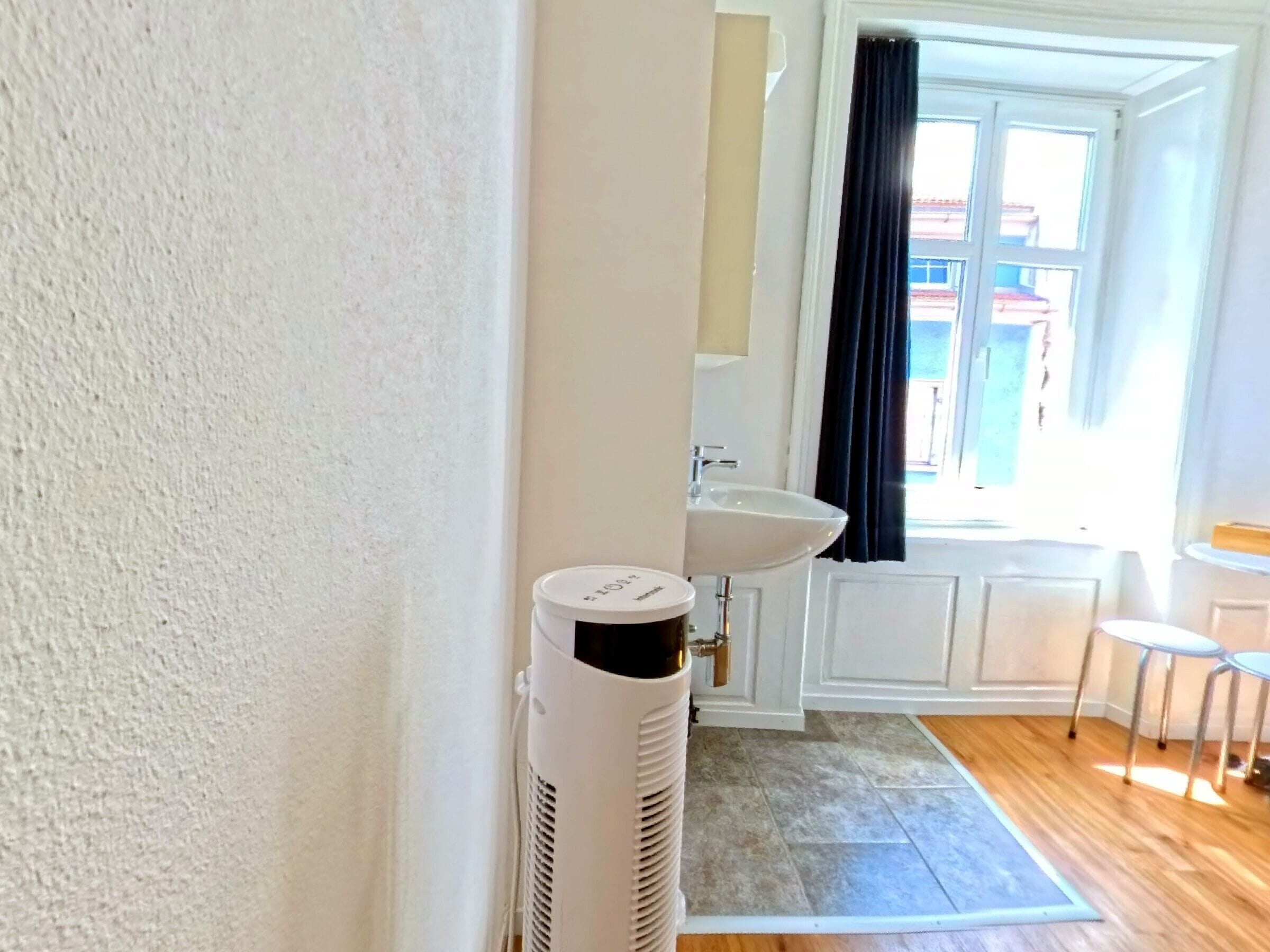 A bathroom with a white sink, a white toilet, and a white heater.