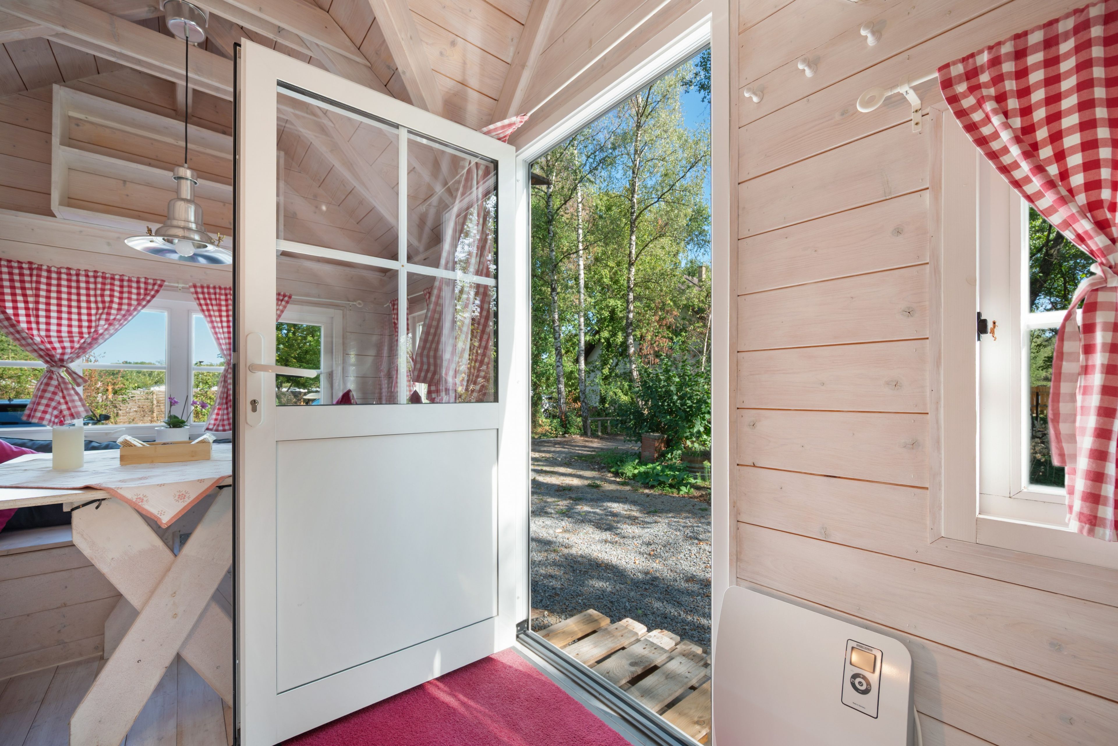Eine Holzhütte mit einer Schiebetür, die in einen Garten führt.