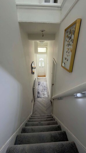 Eine Treppe mit Teppichstufen führt zu einer Tür oben.