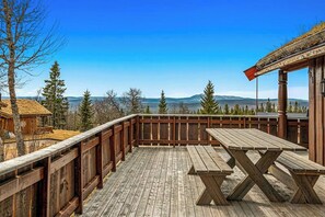 A wooden deck with a picnic table, surrounded by a wooden fence, overlooking a mountainous landscape. - Hilltop cabin with views of Trysilfjellet (Trysil)