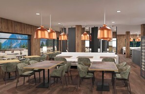 Un interior de restaurante moderno con mesas altas, sillas tapizadas de verde e iluminación colgante de cobre.