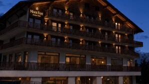 Um hotel com vários andares e varandas, com uma placa que diz 'Mont Fort Boutique Hotel'.