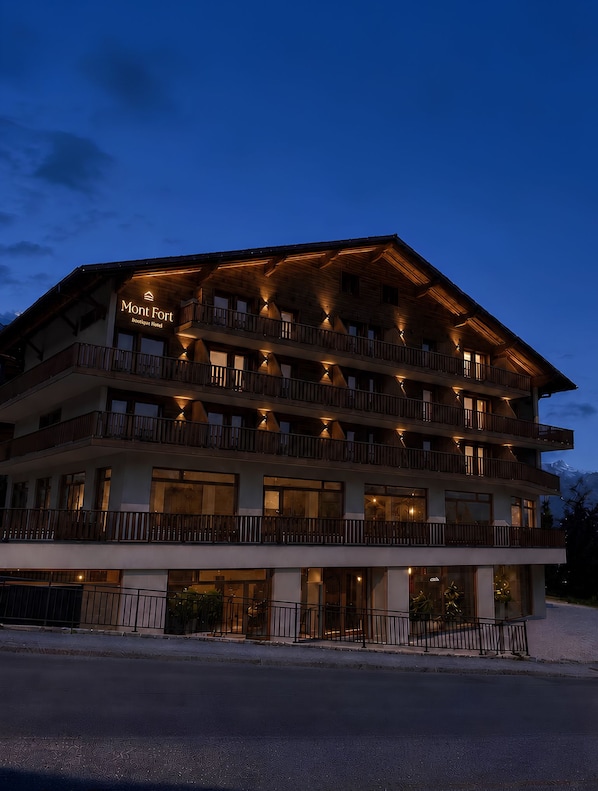 A multi-story hotel with balconies and a sign that reads 'Mont Fort Boutique Hotel.'